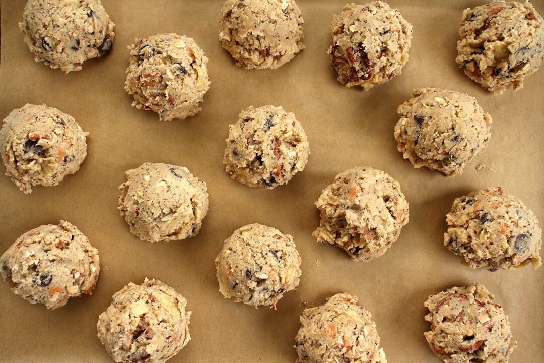 scooped cookie dough on a parchment paper lined baking sheet