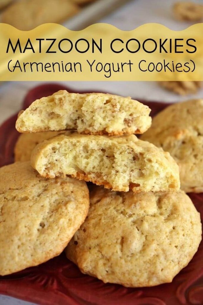 Close up of a plate of fluffy yogurt cookies with one broken in half to show the inside