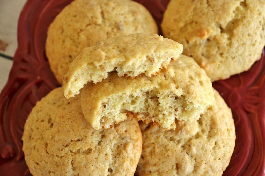Overhead view of a plate of 4 cakey yogurt cookies, with one broken in half