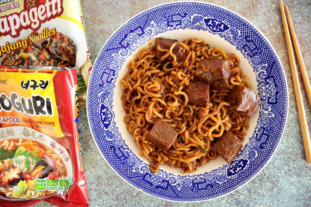 Korean Ram-don (Jjapaguri) noodles with cubed steak served in a shallow bowl.