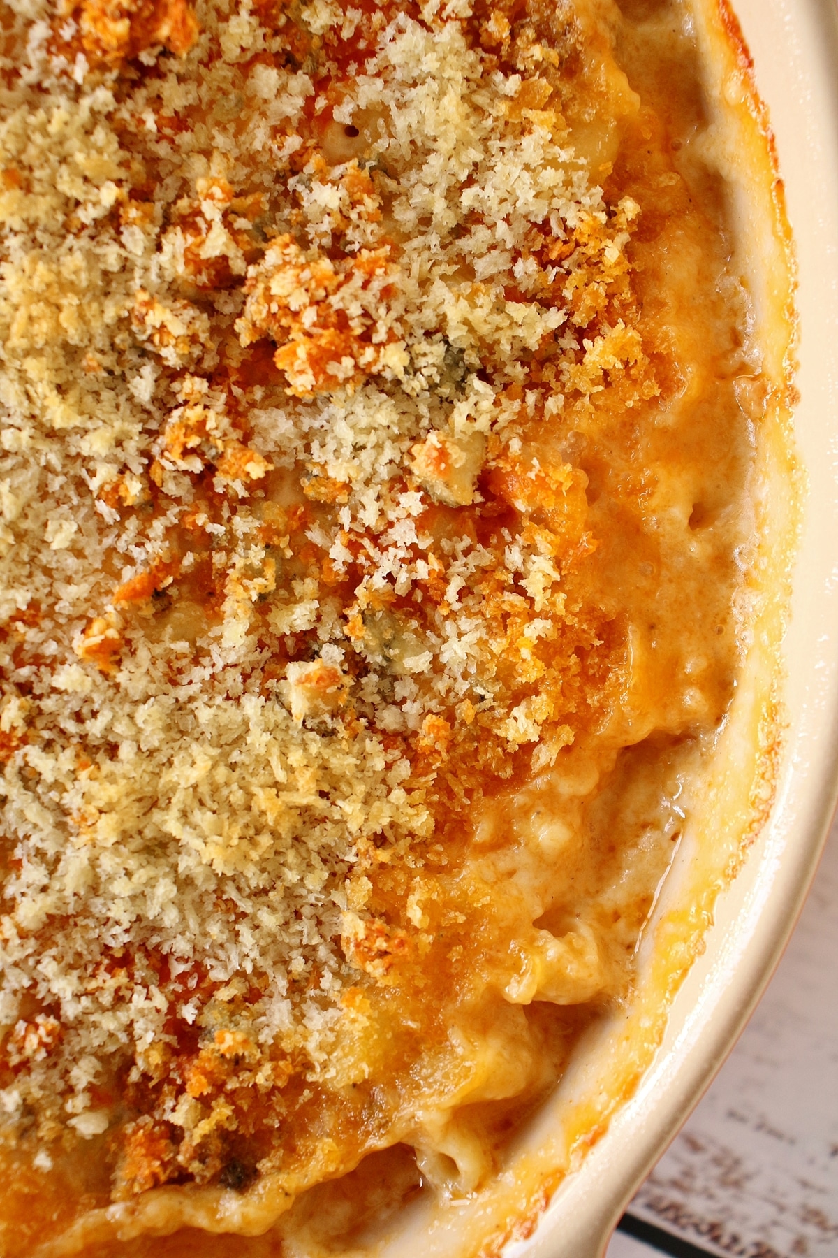 An oval casserole dish filled with bubbly buffalo chicken macaroni and cheese
