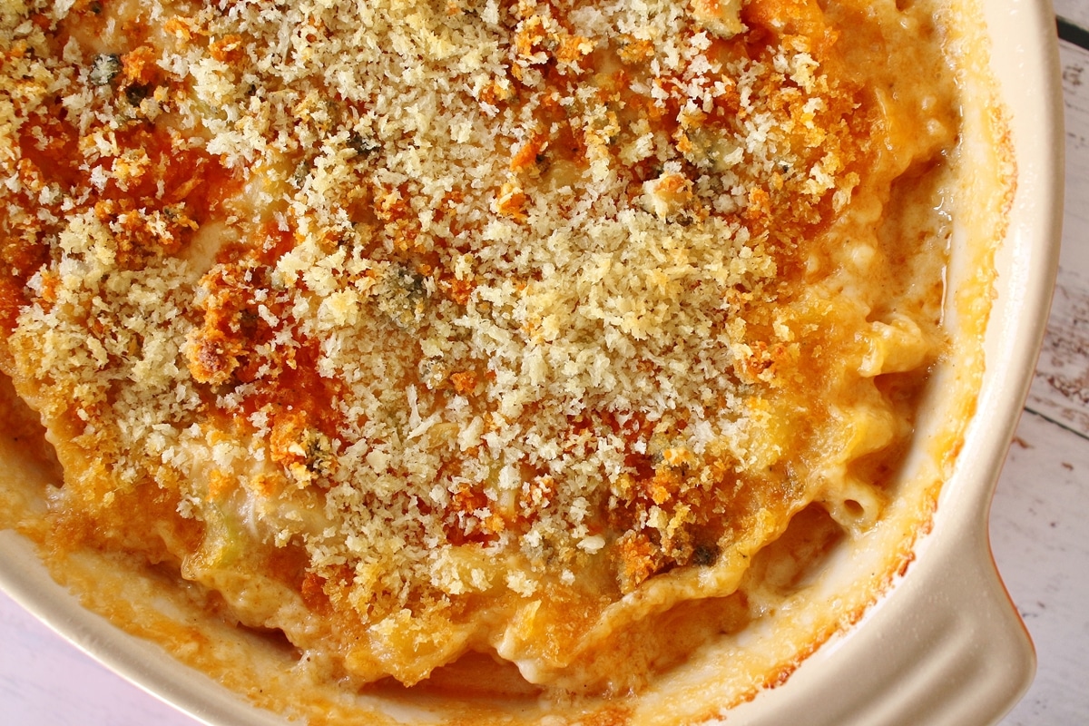 An oval casserole dish filled with bubbly buffalo chicken mac and cheese