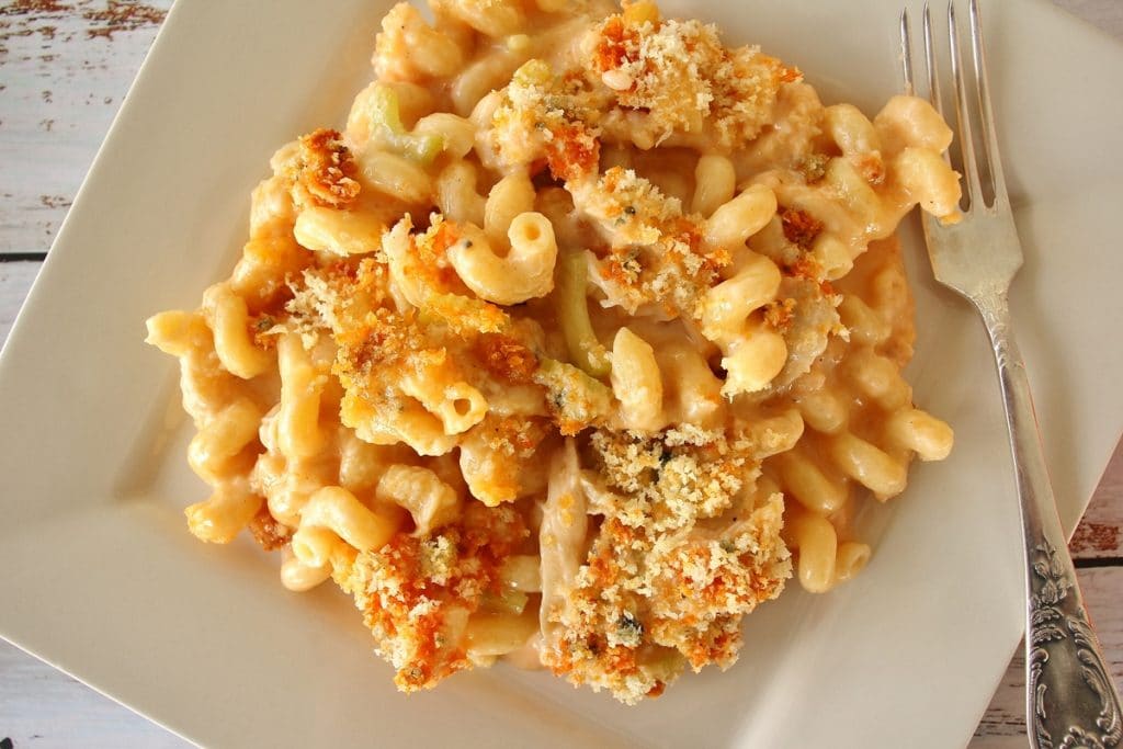 A serving of buffalo chicken mac and cheese on a square plate with a fork to one side