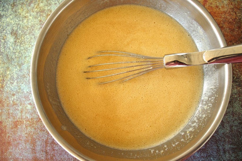 The wet ingredients for chorek whisked together in a metal mixing bowl