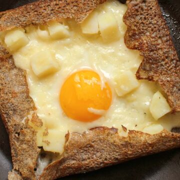 buckwheat galette with egg, potato and cheese in nonstick pan