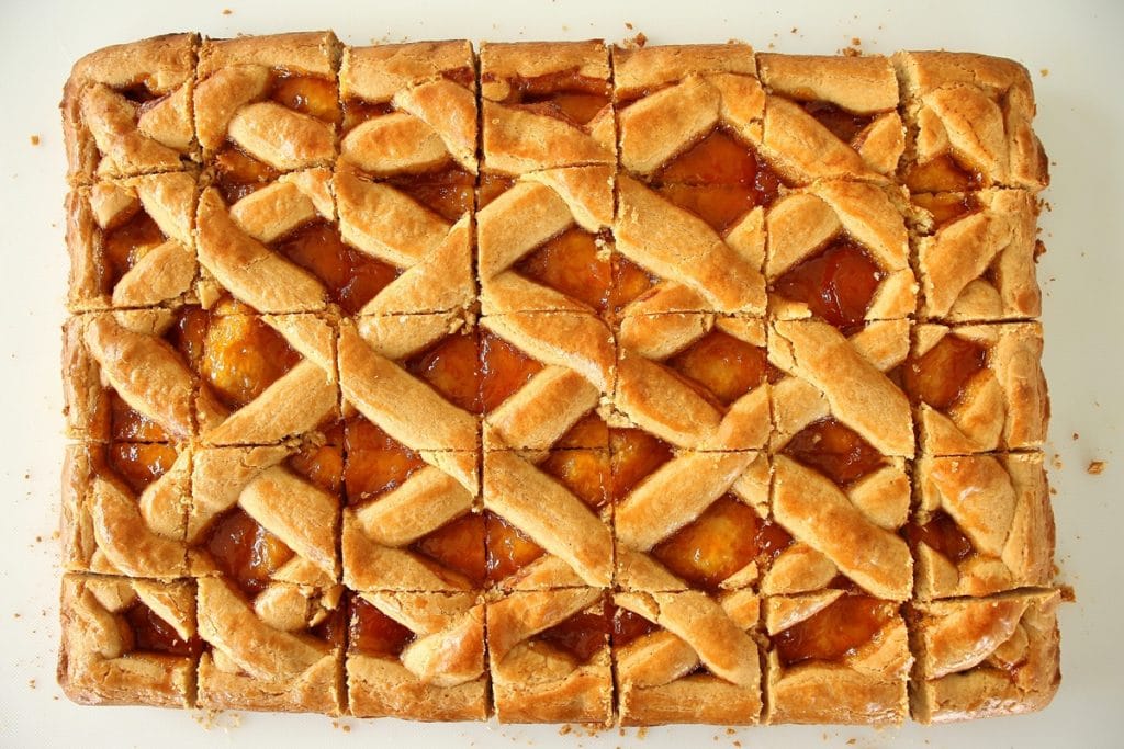Pirog cut into squares on a white cutting board
