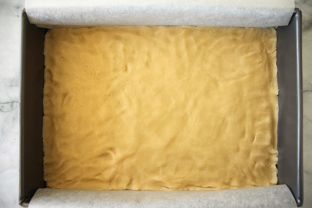 Dough pressed into an even layer in a baking pan