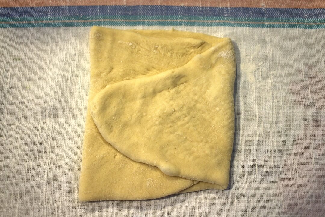 A piece of flattened dough folded into thirds