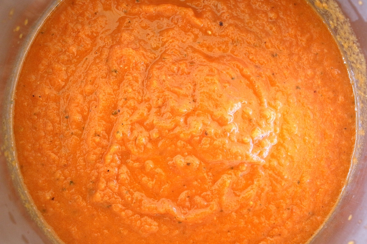 Pureed orange-hued tomato sauce in a saucepan