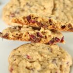 Closeup of a cranberry chocolate chip oatmeal cookie broken in two pieces