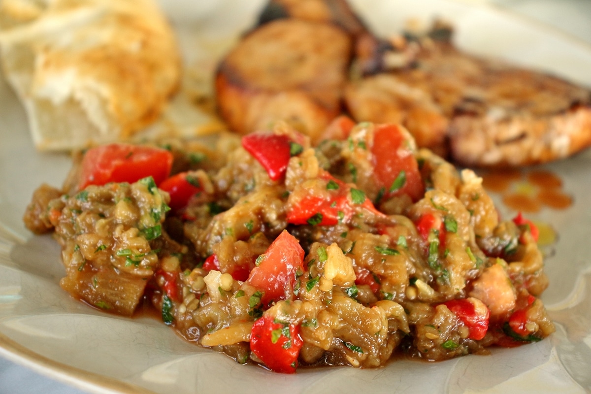 a plate of grilled veggie salad and pork chops