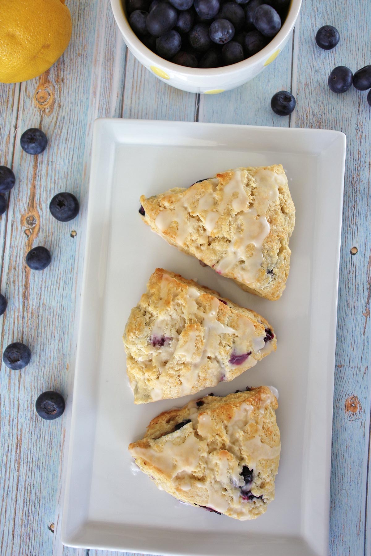 overhead view of 3 blueberry lemon scones on a rectangular white plate