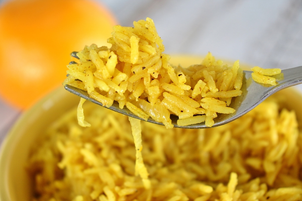 Close up of a forkful of curried citrus rice