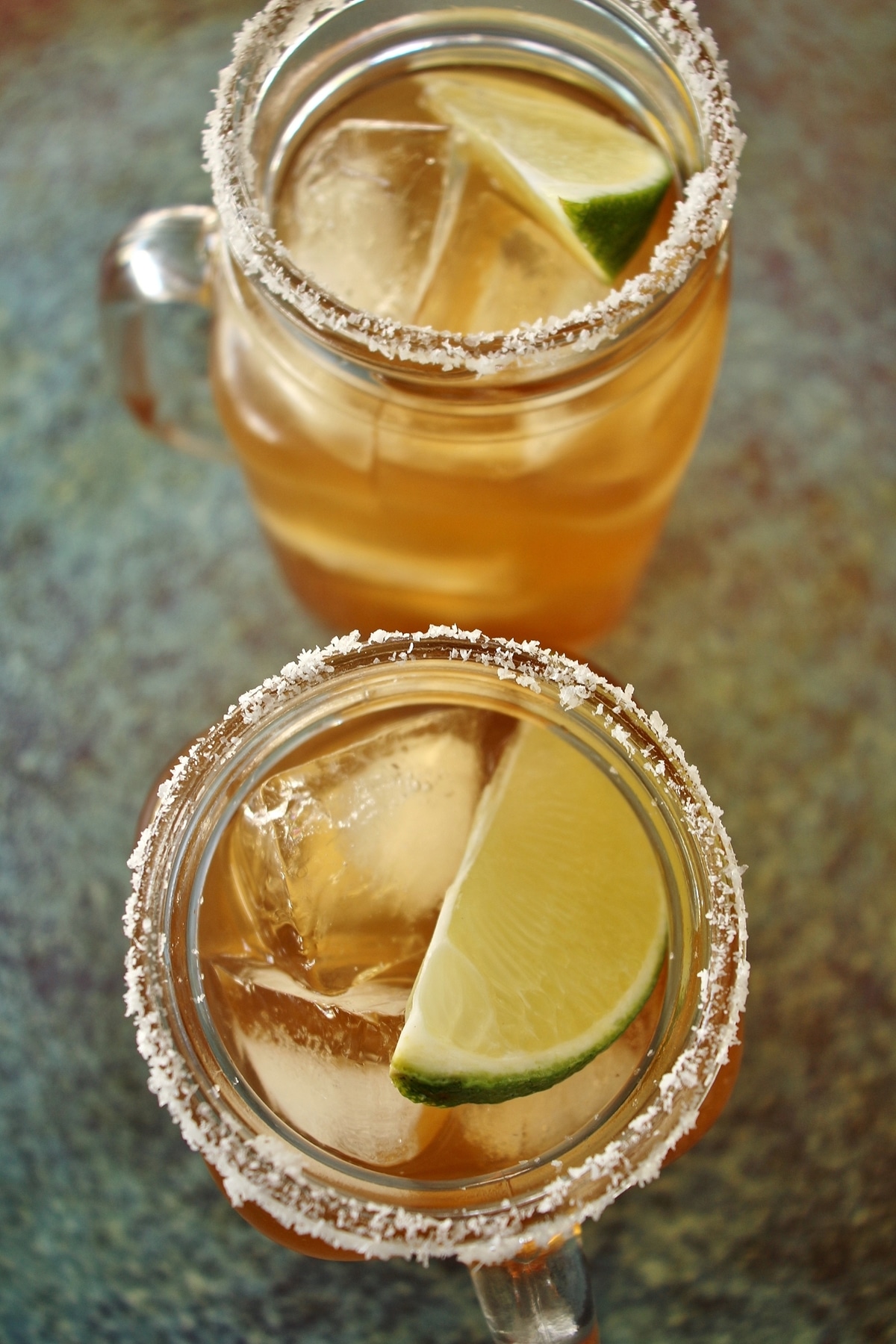 Overhead view of 2 tamarind margaritas with salt rims and lime wedge garnish