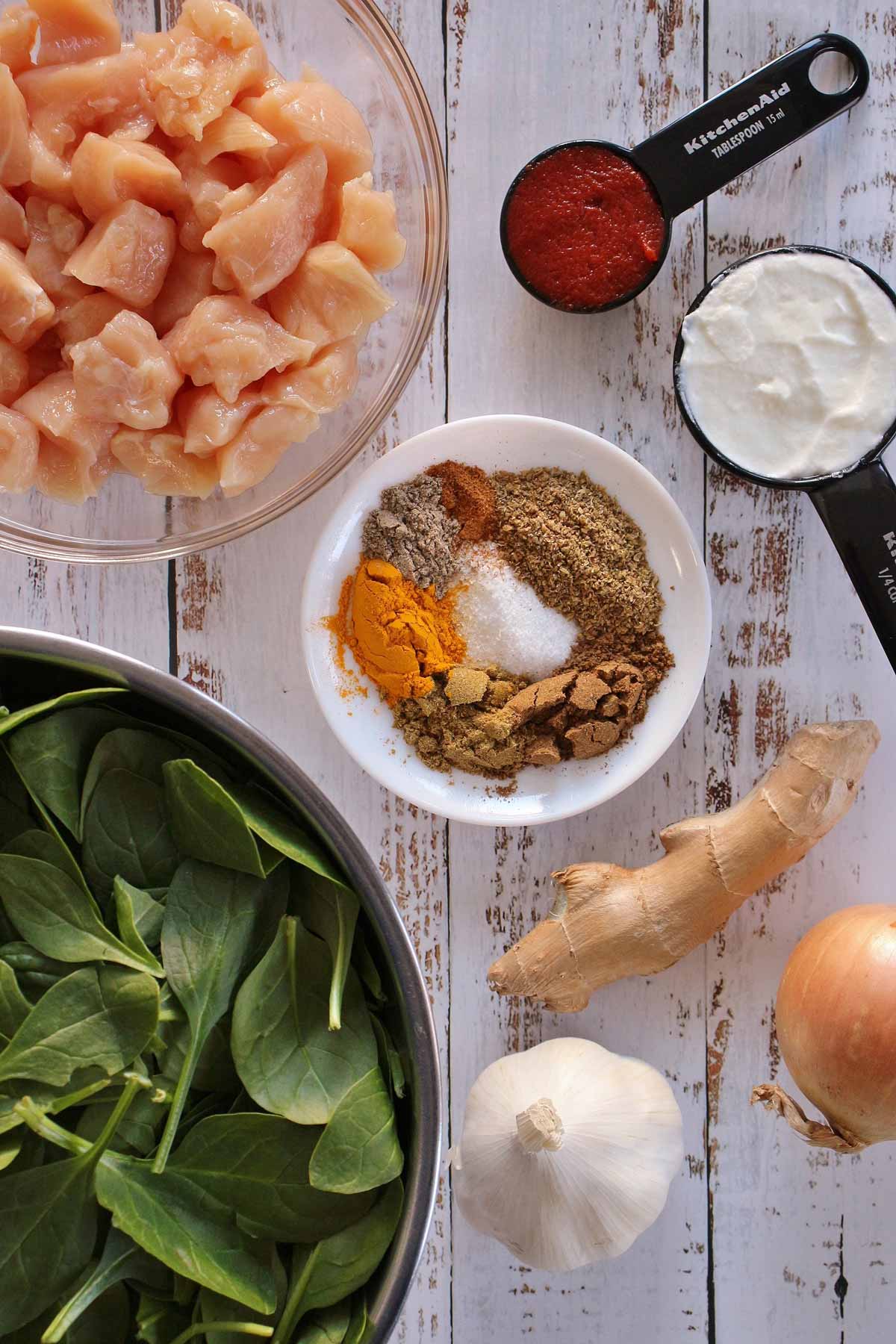 Cubed chicken breast, baby spinach, tomato paste, yogurt, ginger, onion, garlic, and spices.