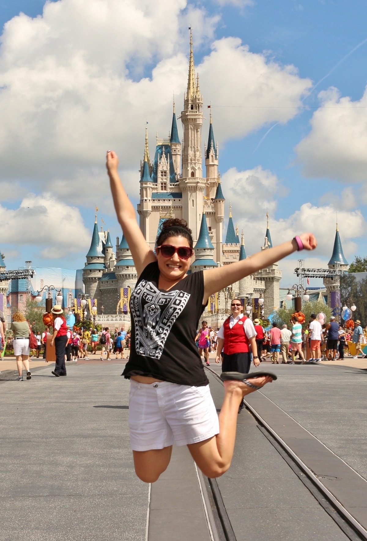 a woman jumping in front of Cinderella Castle in Disney's Magic Kingdom