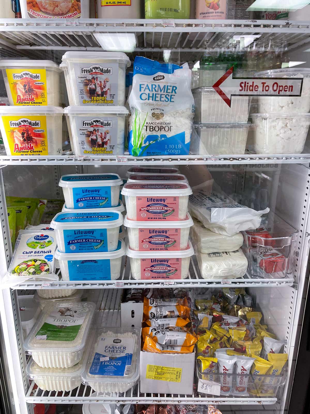 A variety of packages of farmer cheese in a grocery display.