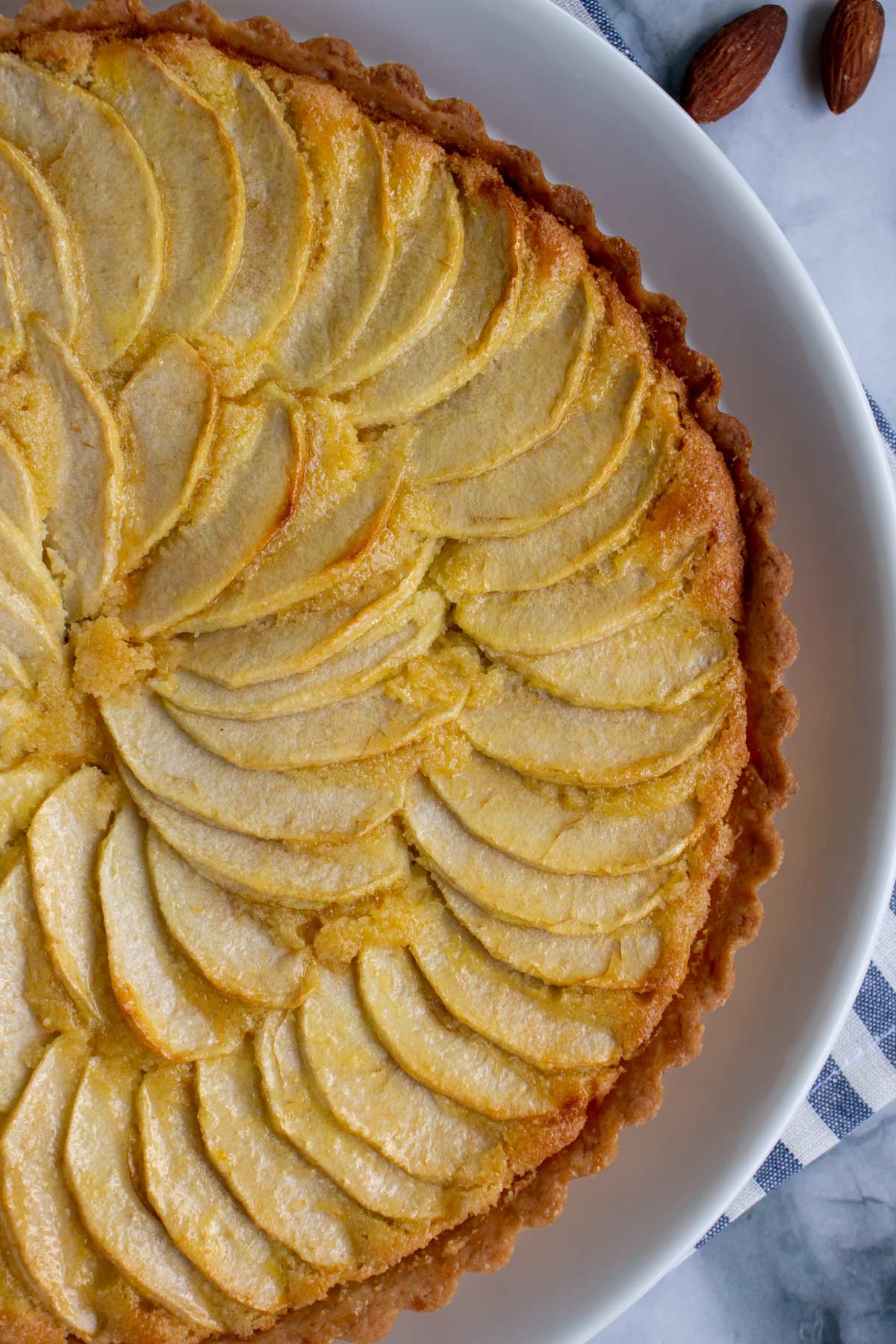 A closeup of fanned apple slices in a spiral pattern on top of a tart.