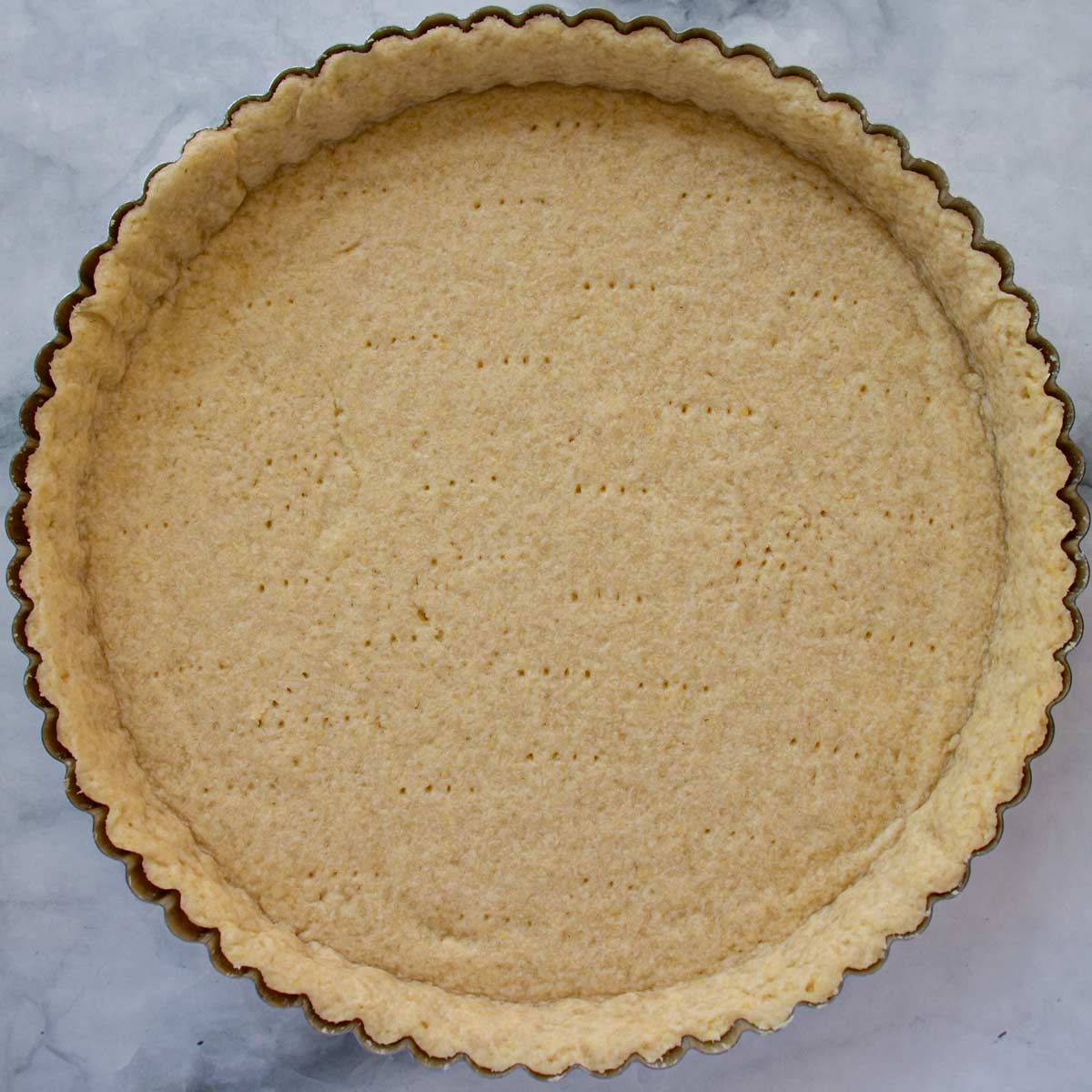 A blind baked tart crust in a round tart pan.