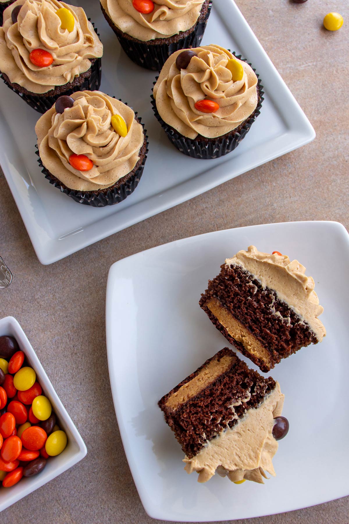 A halved chocolate cupcake on a white plate to show the peanut butter cup inside.