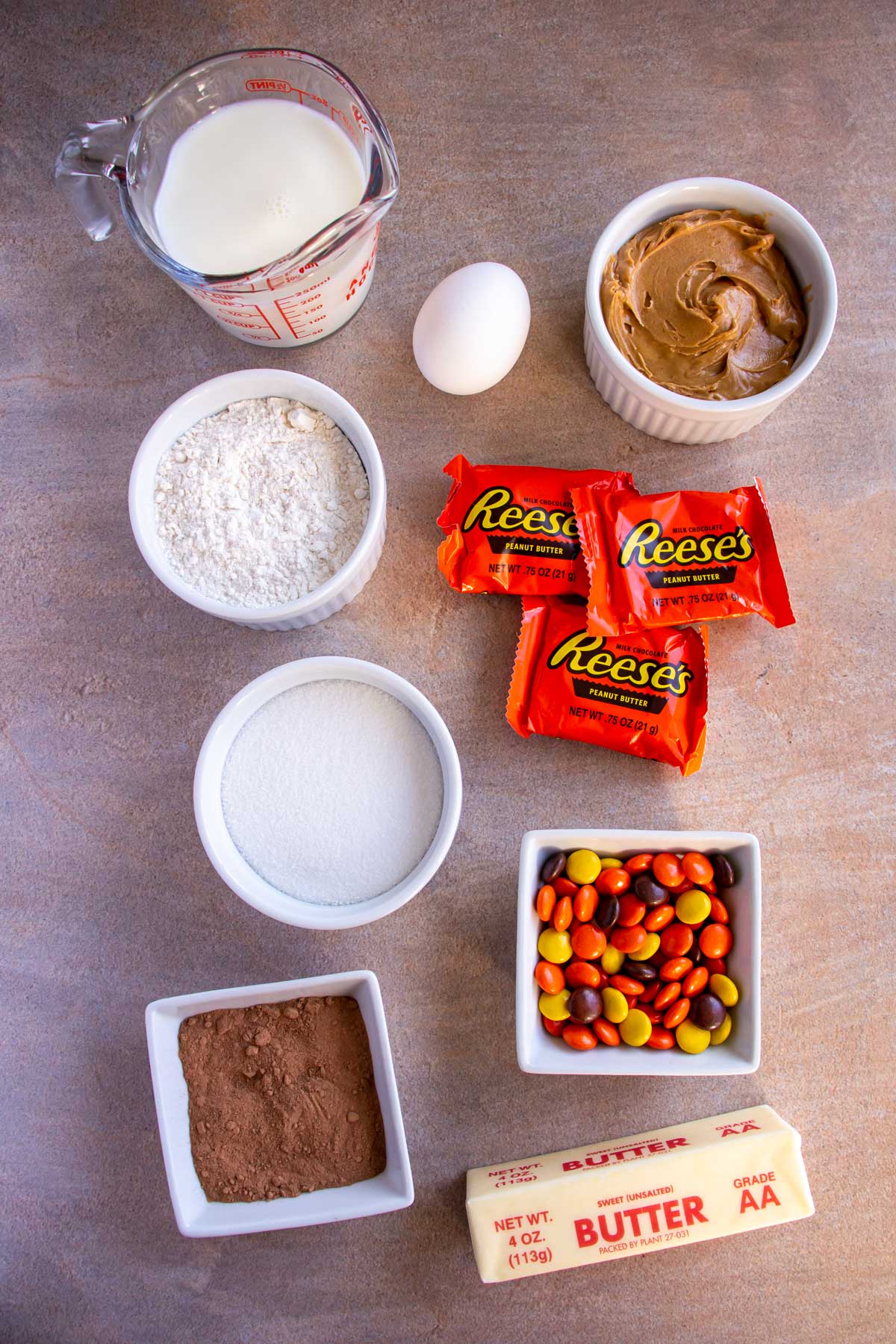 Ingredients for Reese's chocolate peanut butter cup cupcakes on a light brown background.