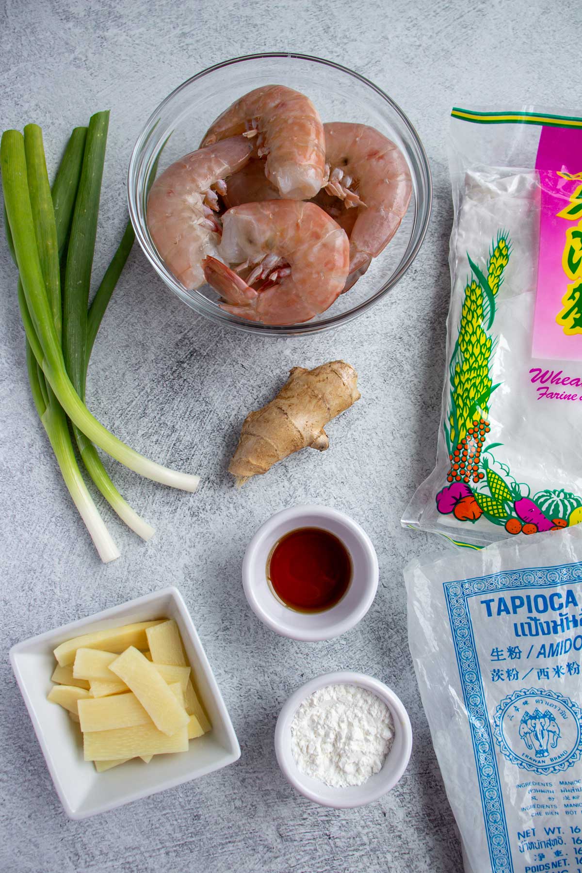 Ingredients for har gow shrimp dumplings on a gray concrete background.