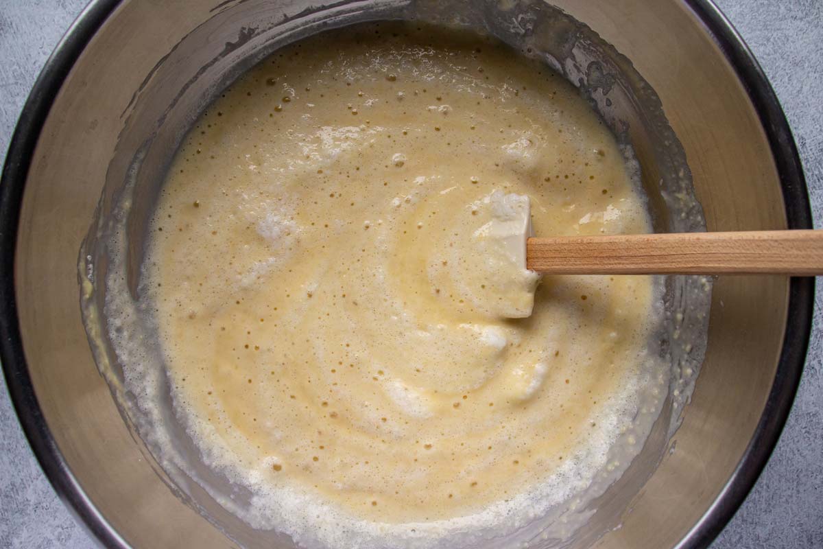 Batter in a metal mixing bowl with streaks of beaten egg whites throughout.
