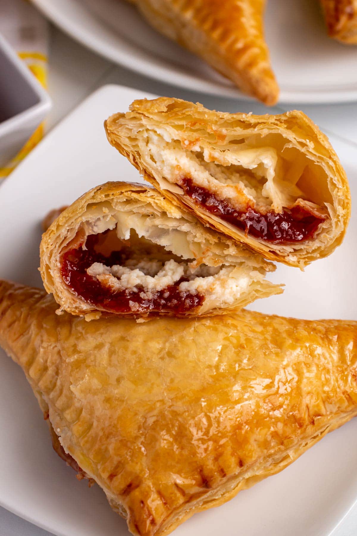 Closeup of cross-section of a guava and cheese pastry showcasing the filling in flaky pastry.