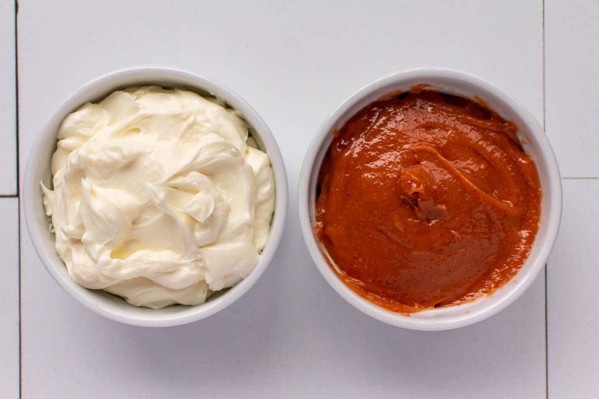 A ramekin of cream cheese filling next to a ramekin of guava filling.