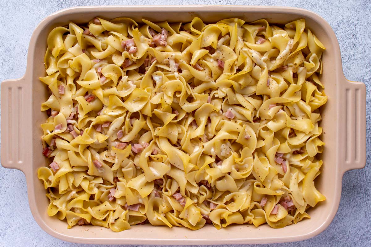 A partially baked casserole of ham and noodles.