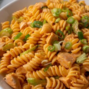 Closeup of Buffalo chicken pasta salad made with rotini, chicken, celery, and scallions.