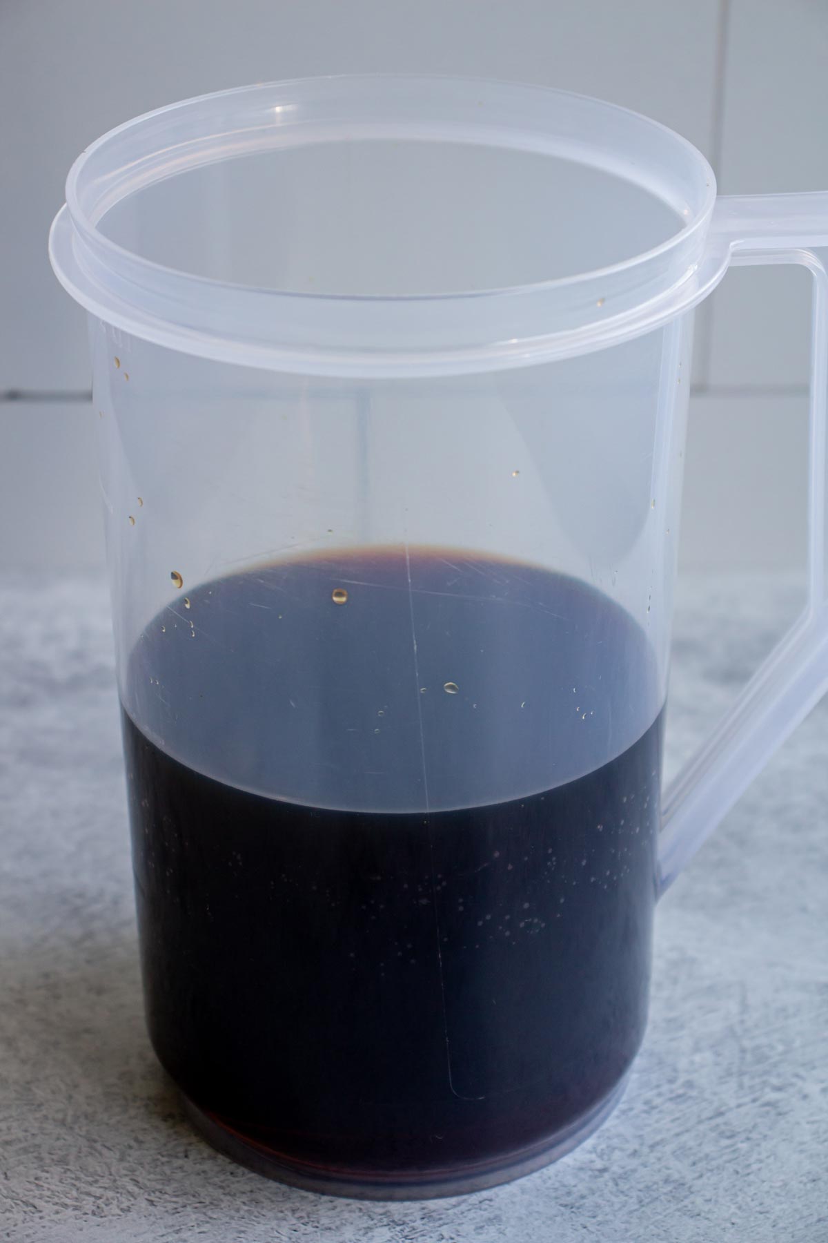 Strained cold brew coffee in a clear plastic pitcher.