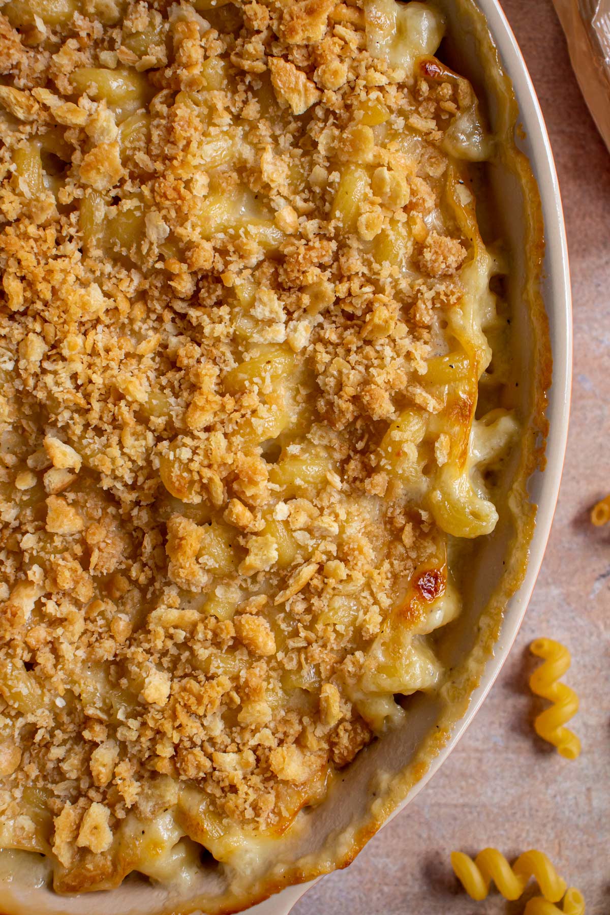 Closeup of bubbly baked macaroni and cheese in an oval baking dish.