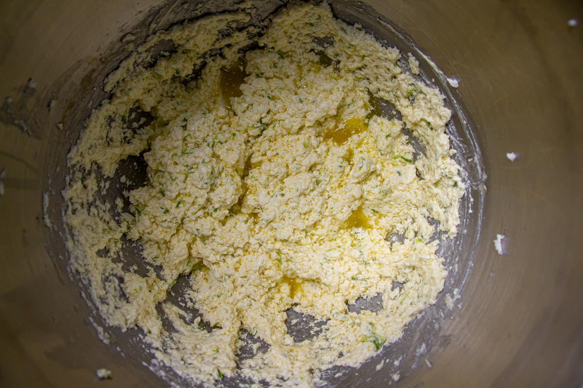 A slightly curdled looking mixture in a metal mixing bowl.