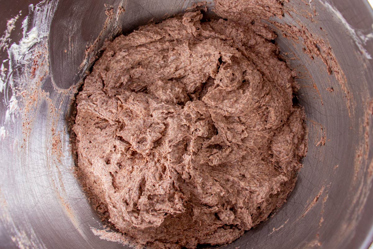 A lighter colored chocolate cake batter in a metal mixing bowl.