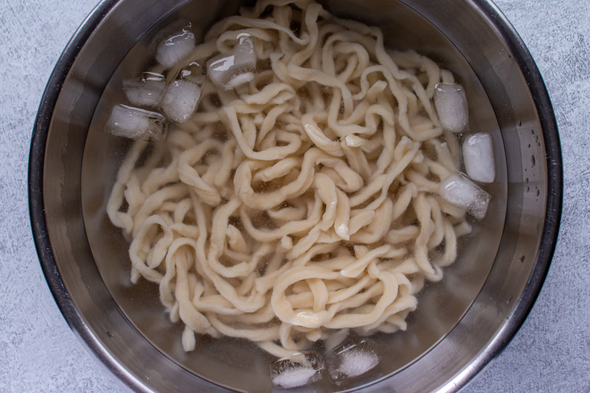 Boiled udon noodles in an ice bath.