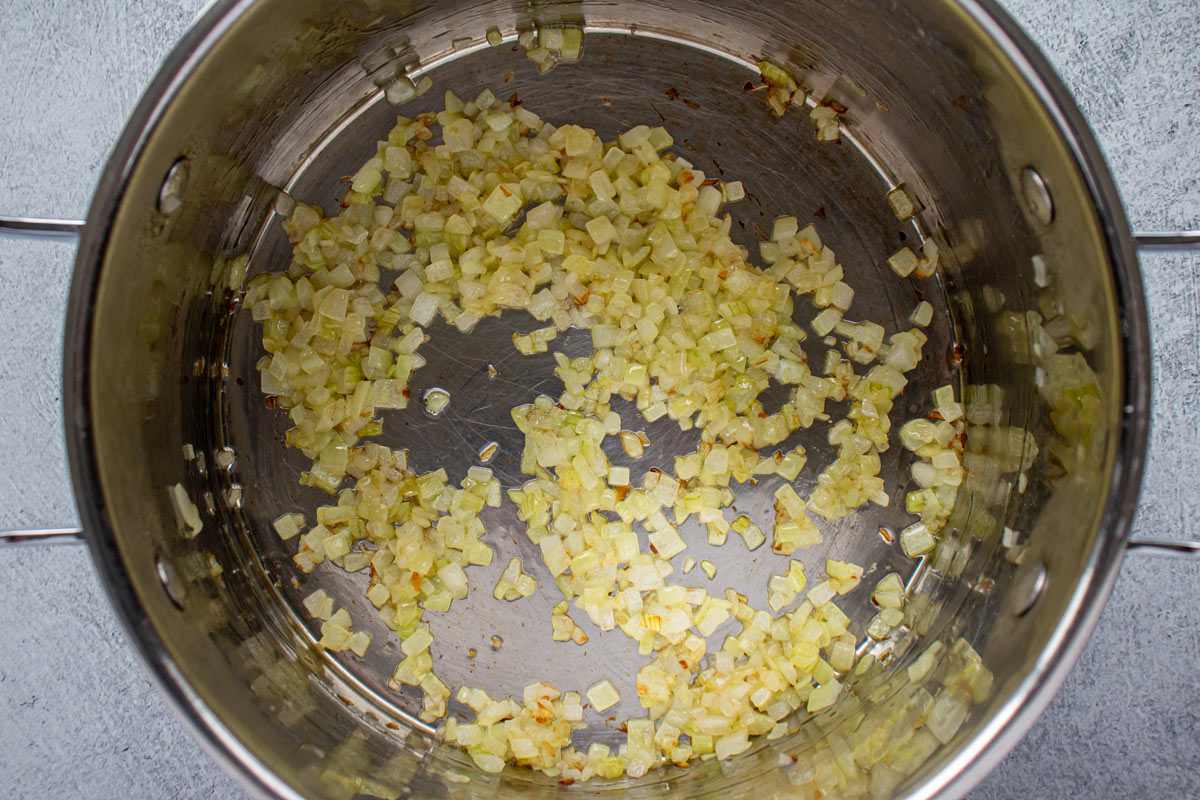 Sautéed chopped onions in a metal pot.