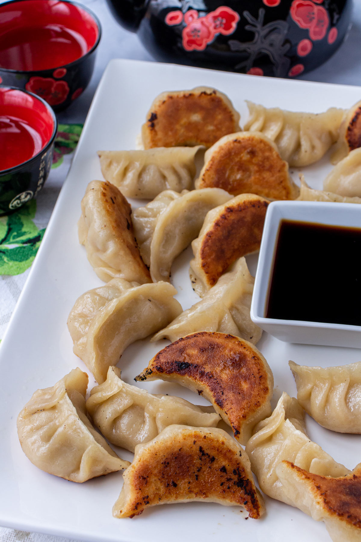 A platter of pan-fried Chinese dumplings with some upside down to show their crispy bottoms.