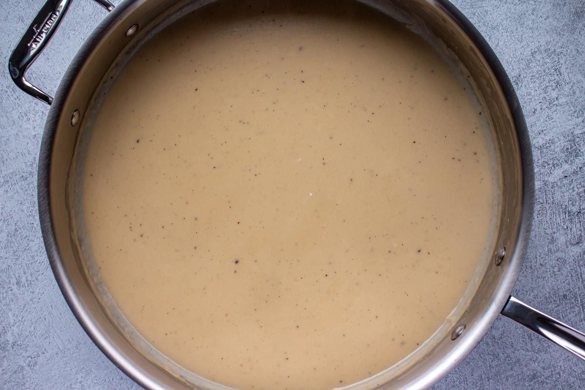 Creamy gravy in a stainless steel skillet.