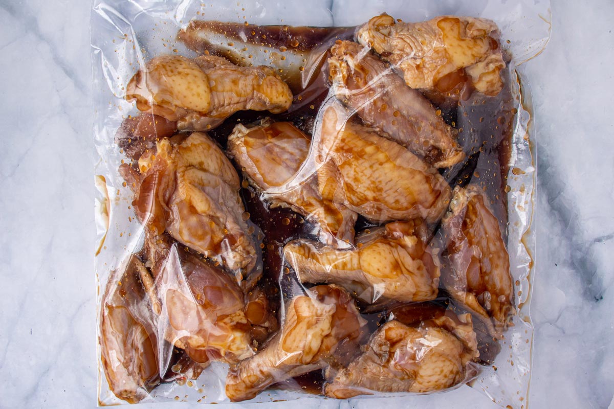 Chicken wings marinating in a plastic zip-top bag.