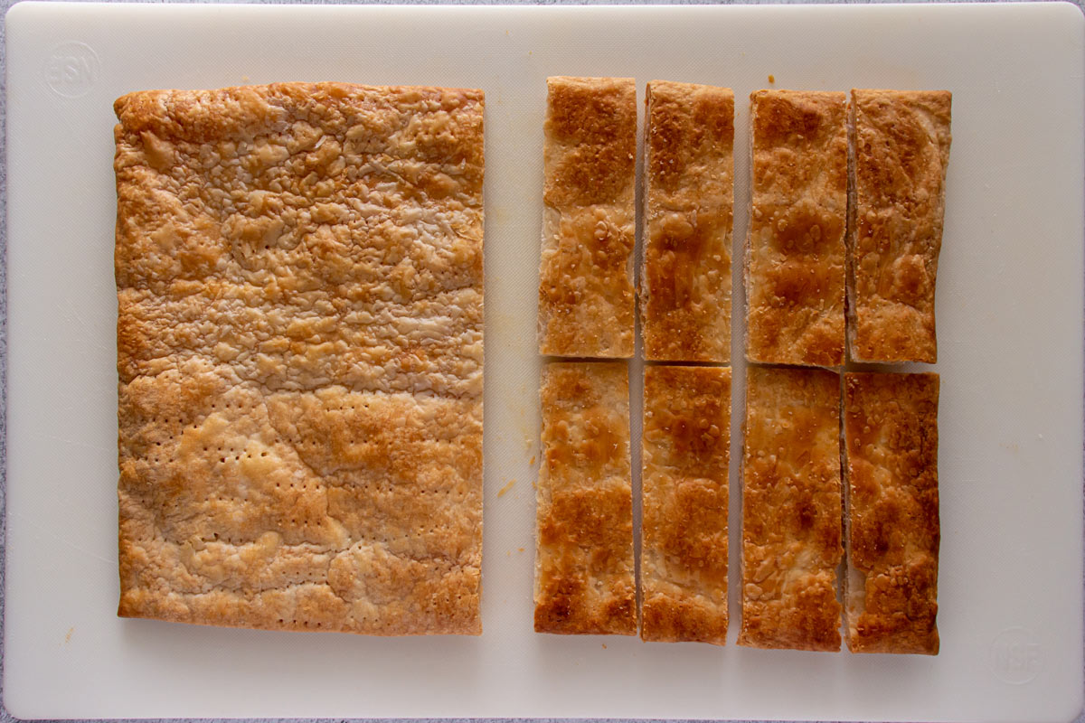 A baked sheet of puff pastry cut in half, and then half cut into small rectangles.