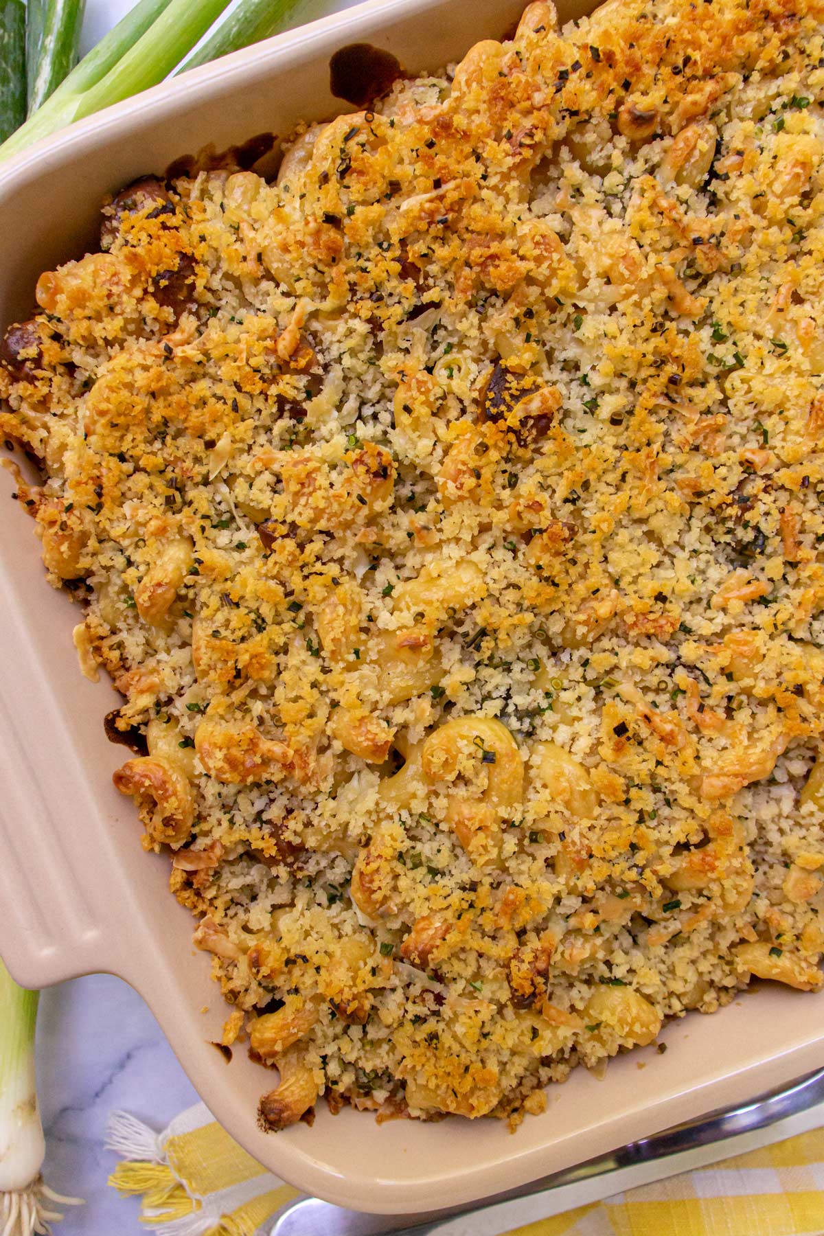 Closeup of a casserole dish of baked mac and cheese with a browned panko crust.