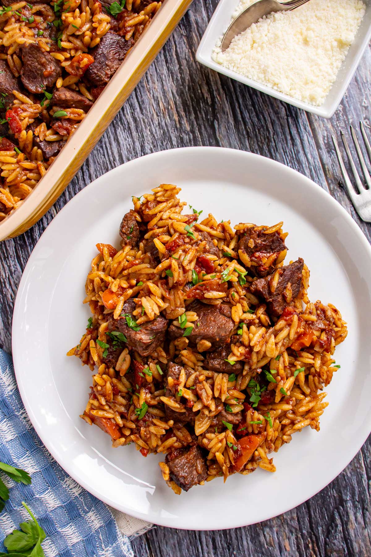 A serving of Greek beef stew and orzo casserole (youvetsi) on a white plate.