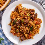 A serving of giouvetsi Greek beef stew and orzo casserole on a white plate.