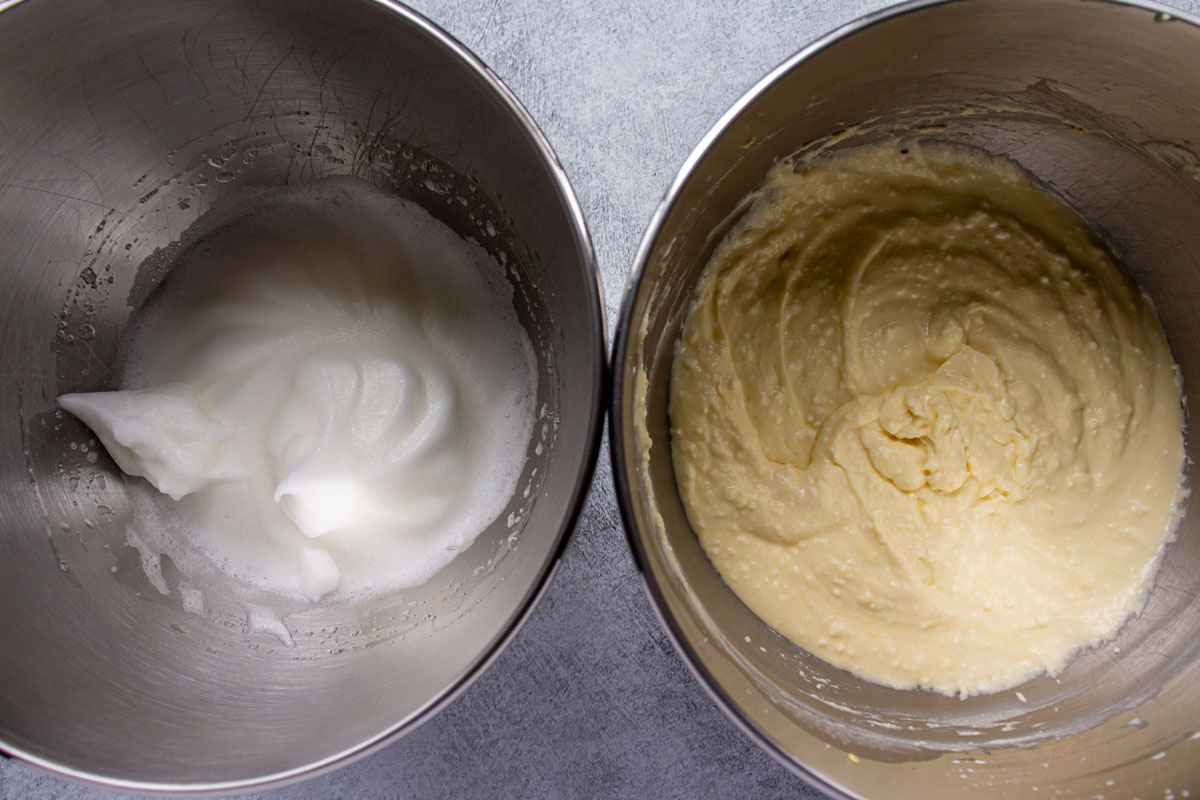 Bowls of whipped egg whites and cheesecake batter side by side.