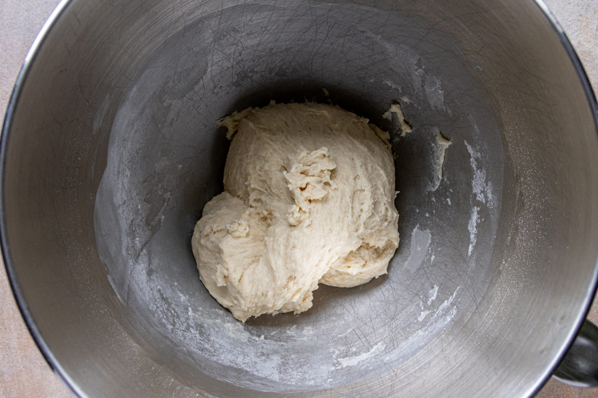 Soft yeast dough in a metal bowl before proofing.
