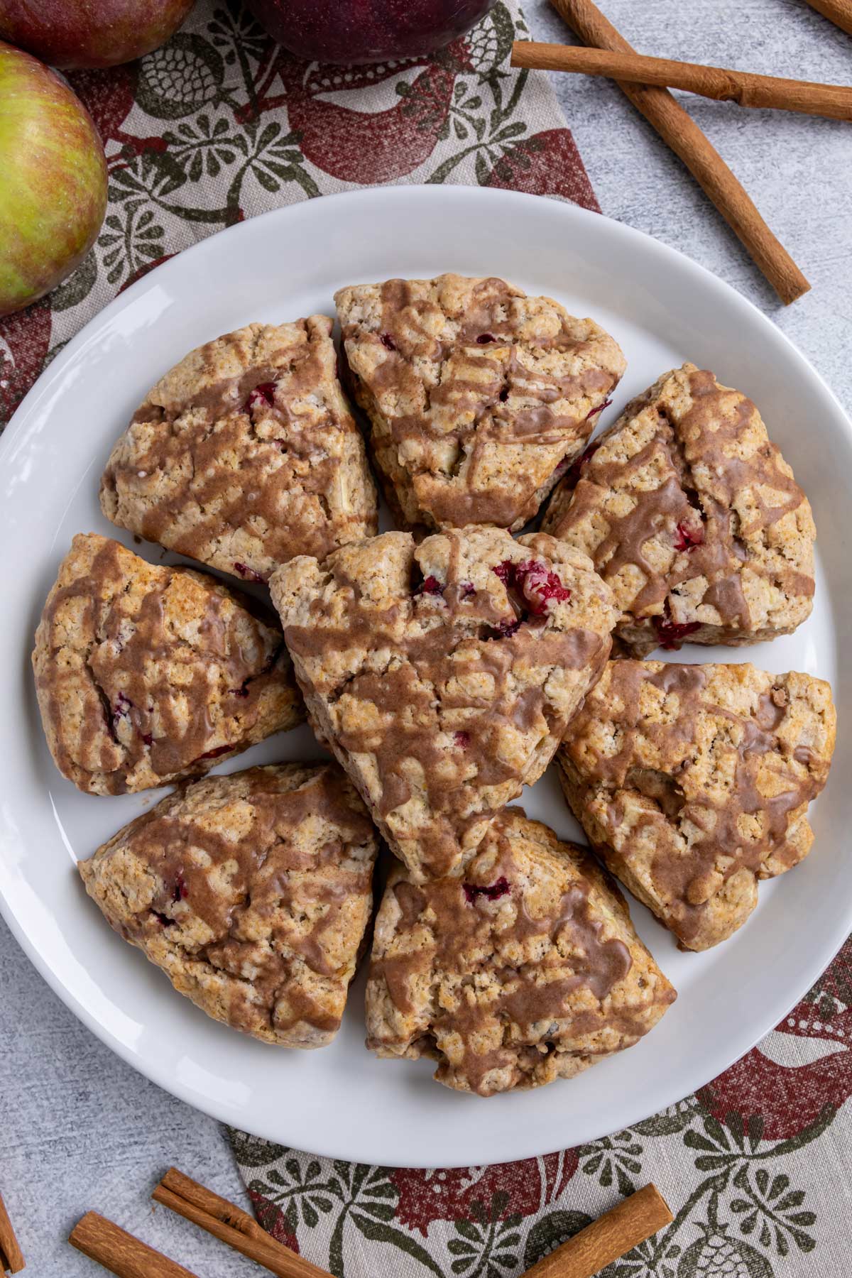 Triangular cranberry apple scones arranged in a circle with one sitting on top.