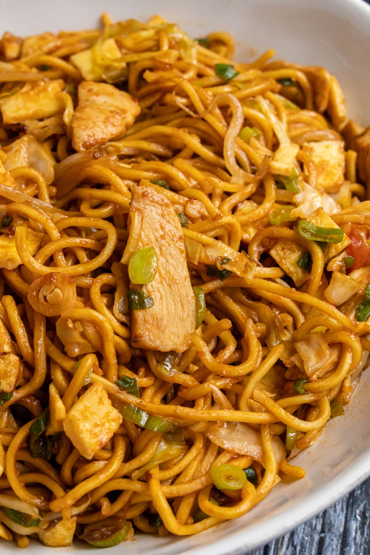 Indonesian stir-fried noodles with sliced chicken, scallions, omelet, cabbage and bean sprouts.
