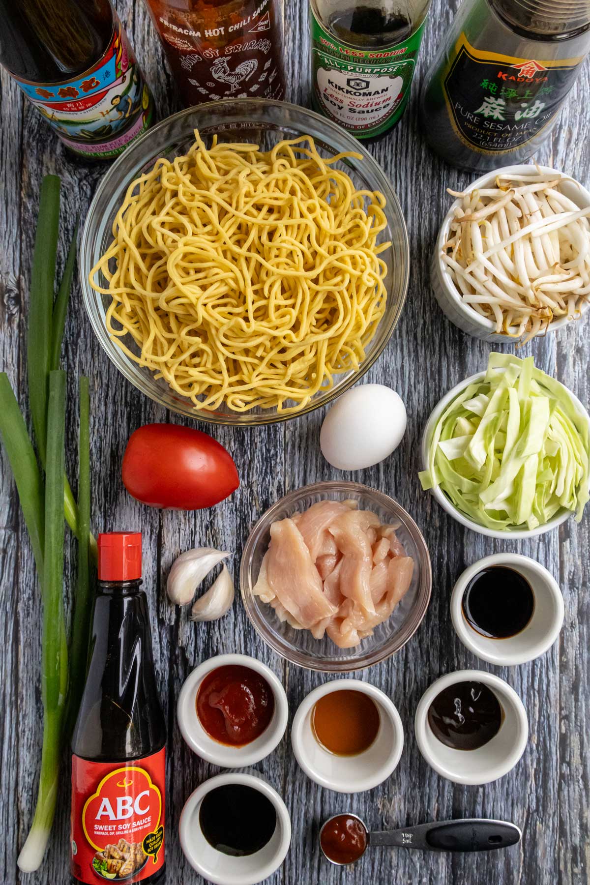 Ingredients for mie goreng Indonesian stir-fried noodles on a blue-grey wooden background.