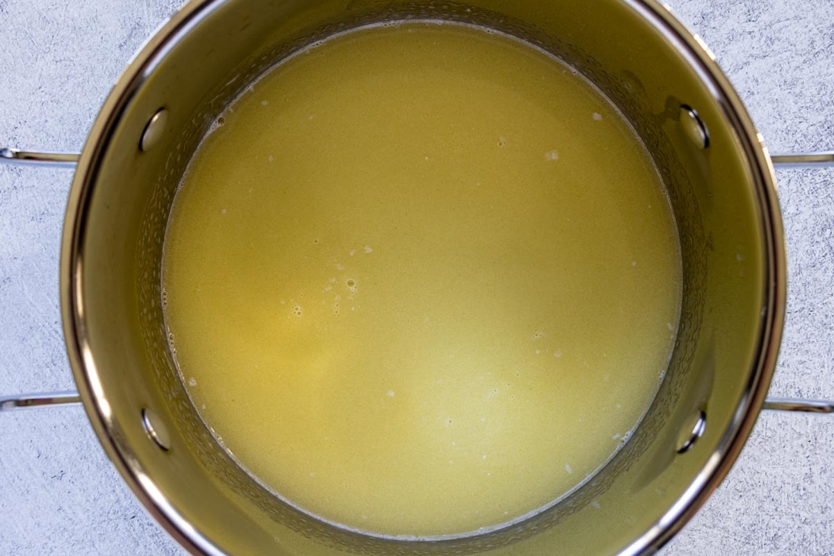 A mixture of melted butter and water in a saucepan.